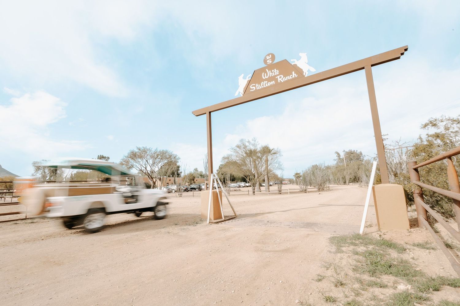 Panoramic view of wooden structures in an arid desert landscape under bright blue sky.