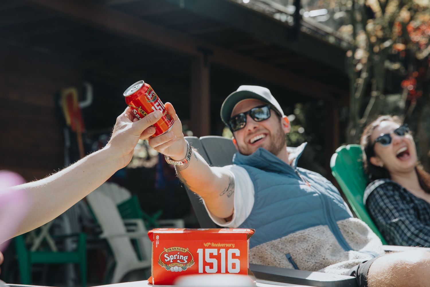 Friends enjoying drinks and snacks while relaxing outdoors on a sunny day.