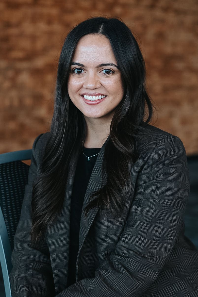 Professional portrait against brick wall background.