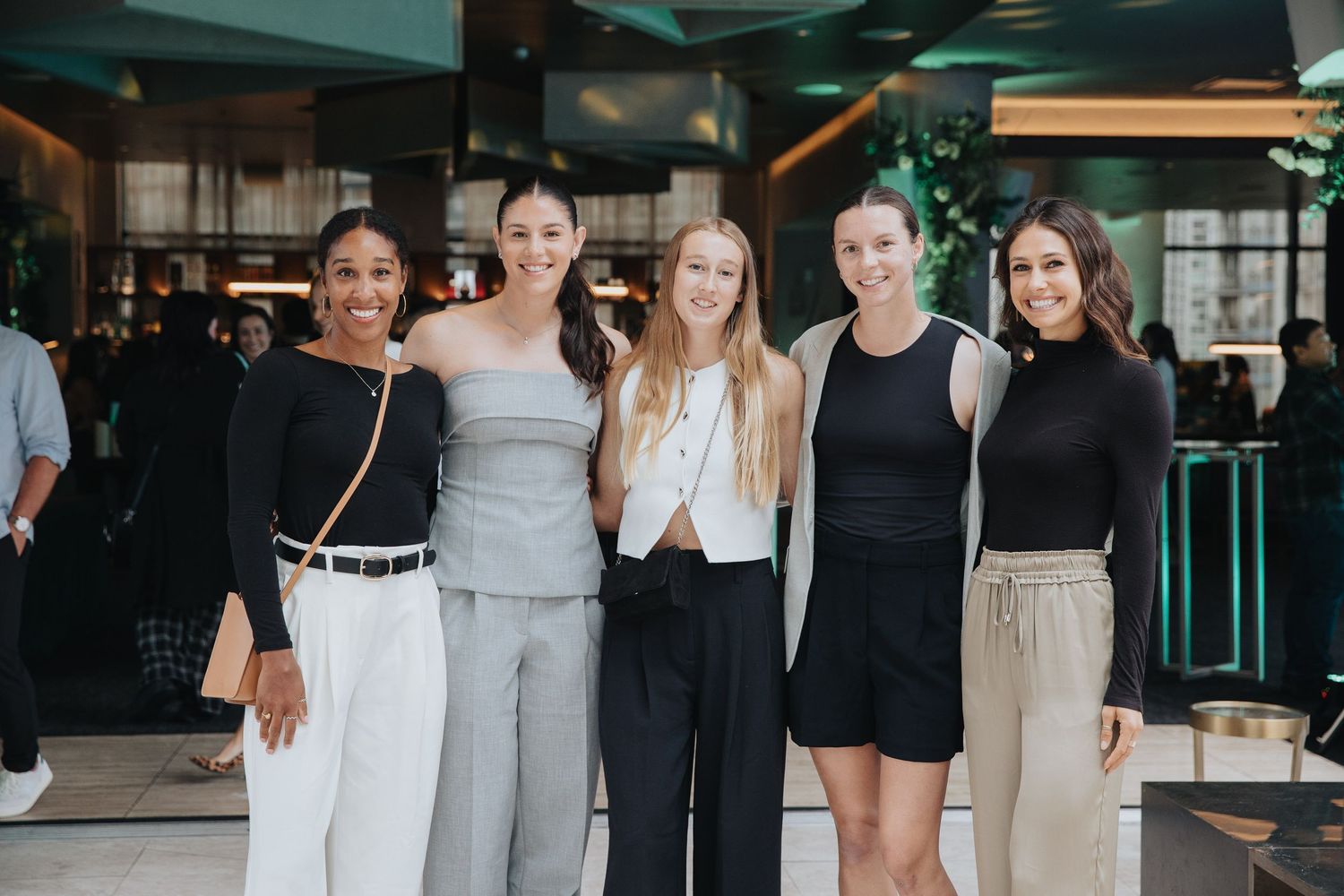 Group photo of team members in coordinated black and neutral outfits.