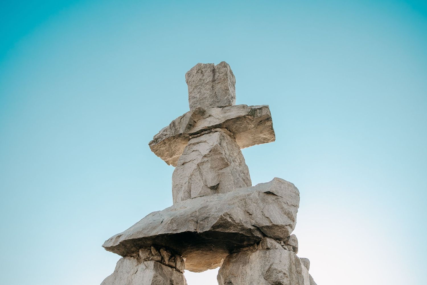 Abstract rock formation sculptures against bright blue sky.