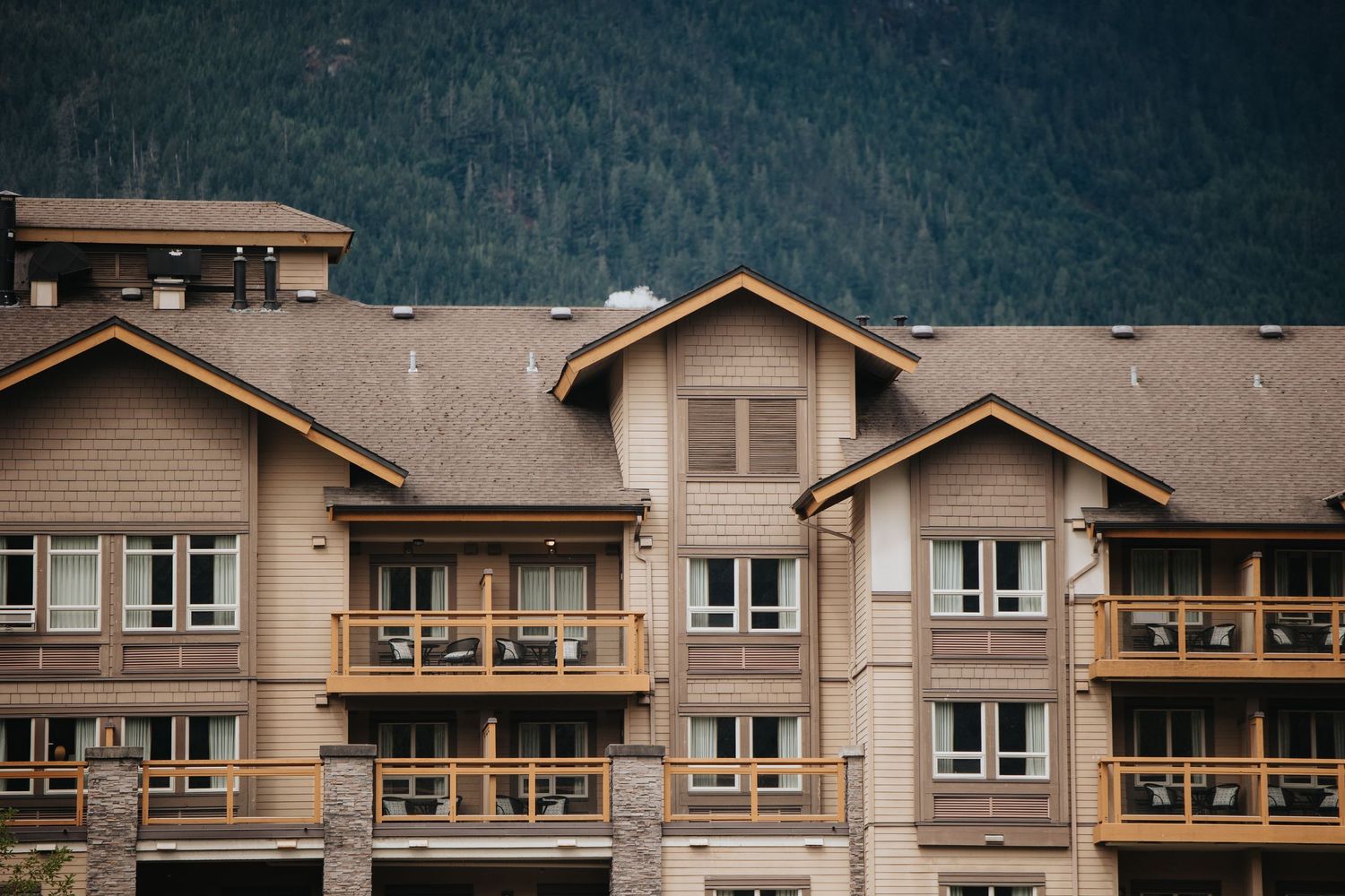 Mountain view of multi-story residential building with wooden balconies.
