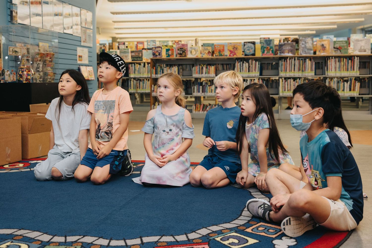Children sitting on the floor in a library during storytime.