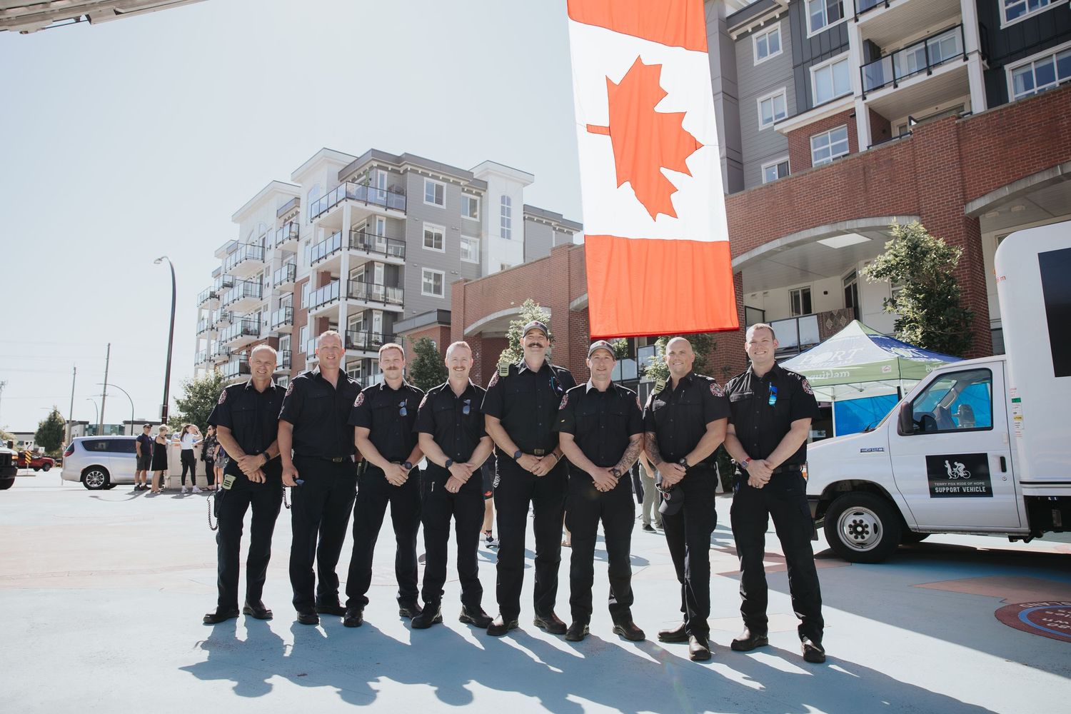 Row of people in matching uniforms standing in formation outdoors.