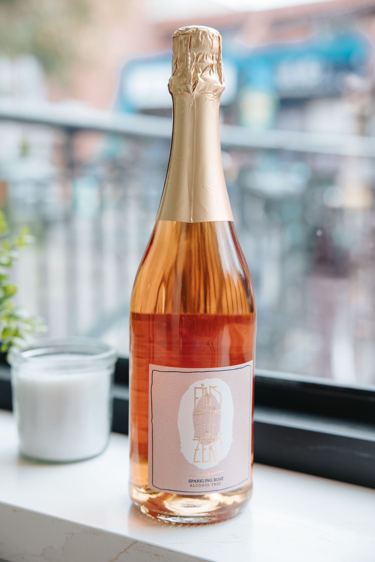 Elegant bottle of rose champagne displayed on a table with natural lighting.