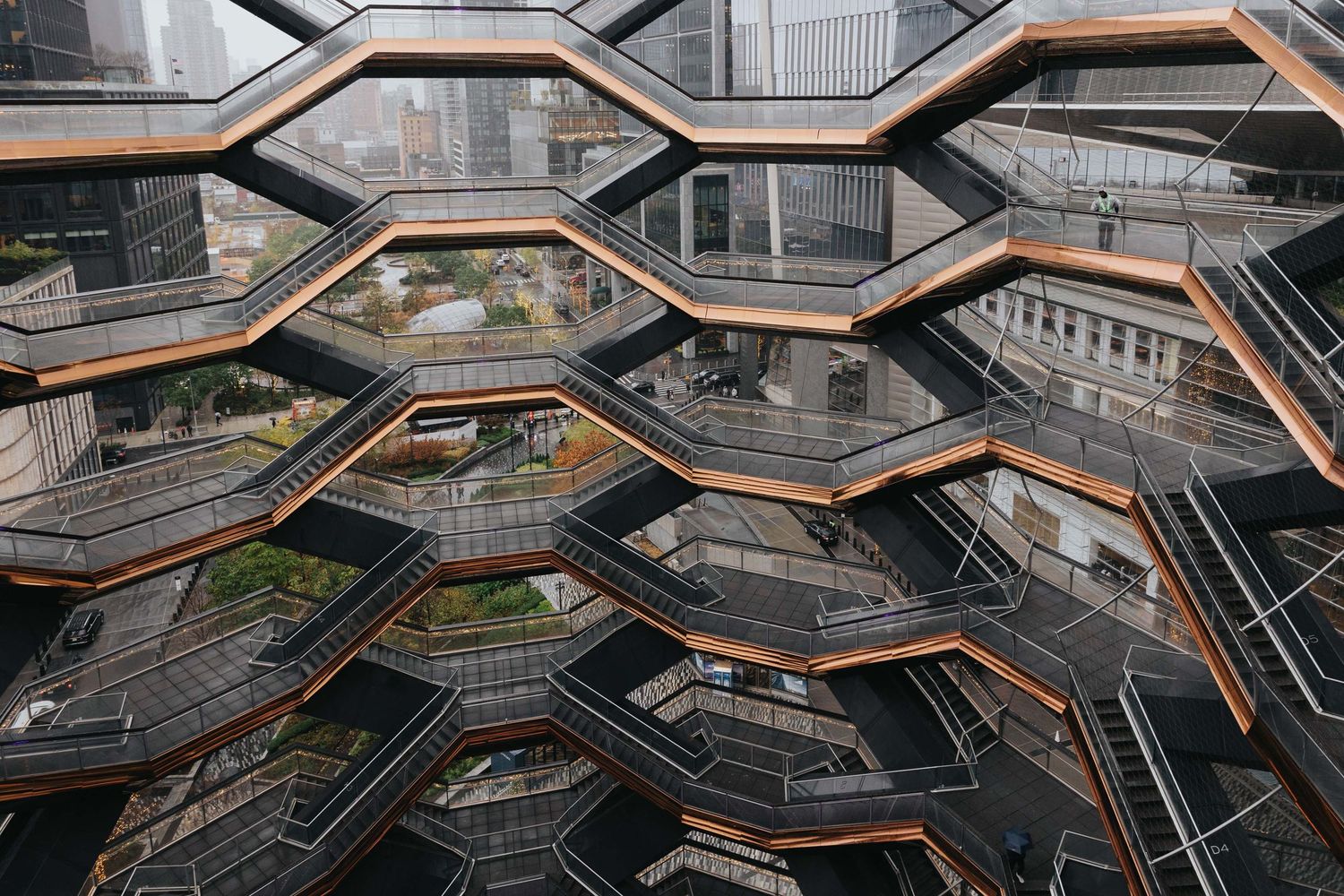 Geometric wooden escalators and walkways create an intricate pattern in a modern architectural space.
