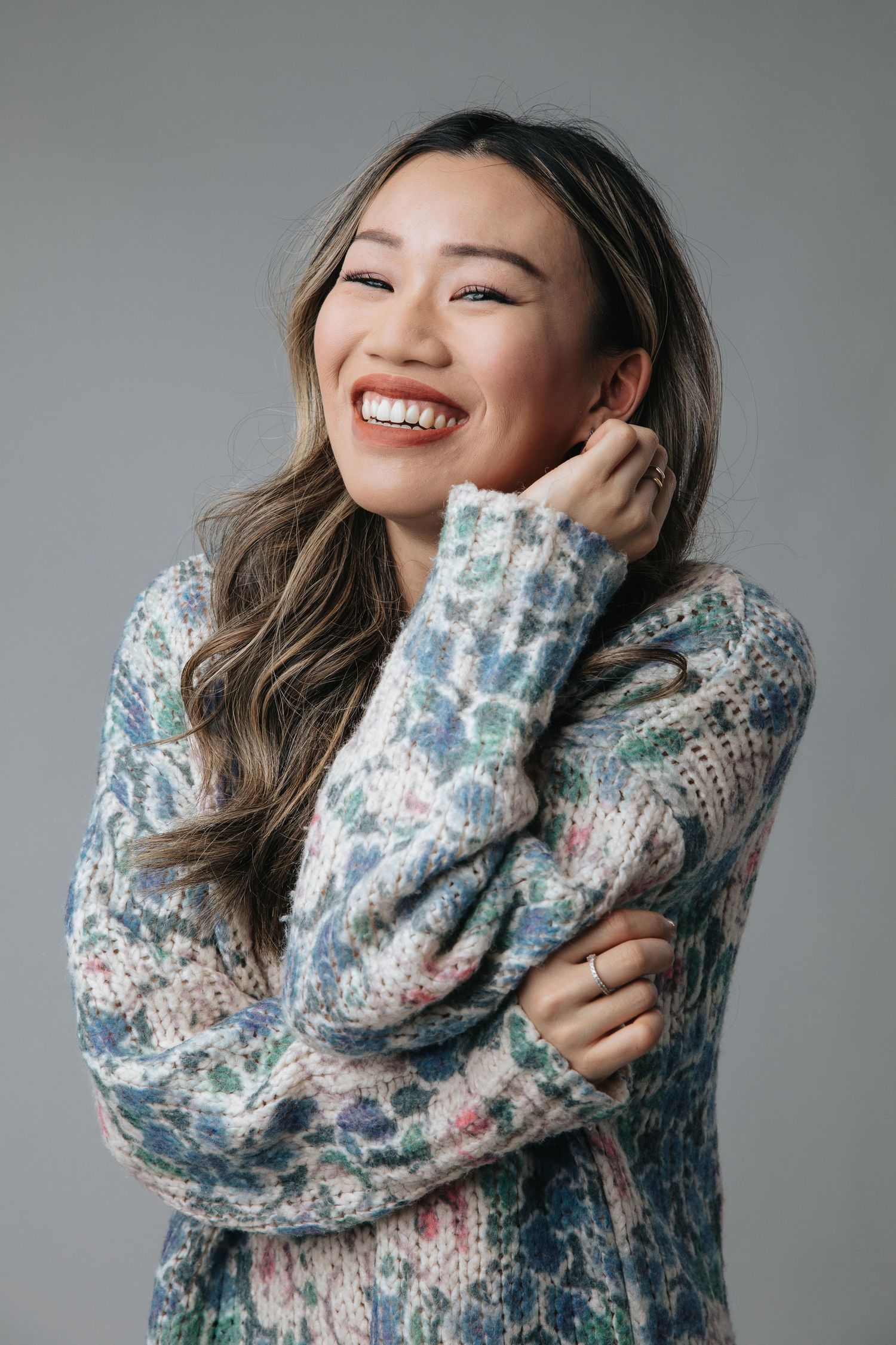 Candid portrait of person wearing cozy patterned sweater with joyful expression.