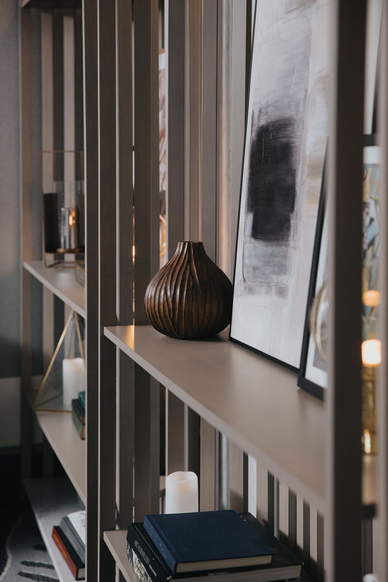 Modern interior hallway with wooden slats and framed artwork on display.