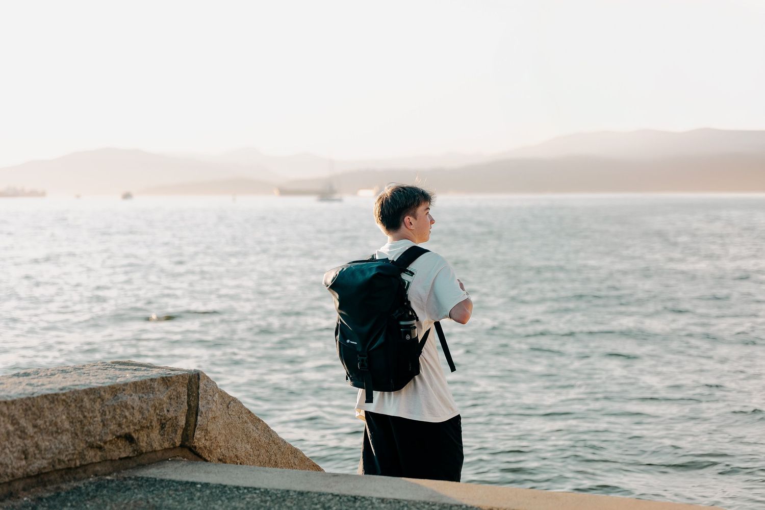 Backpacker enjoying peaceful ocean view from coastal viewpoint.