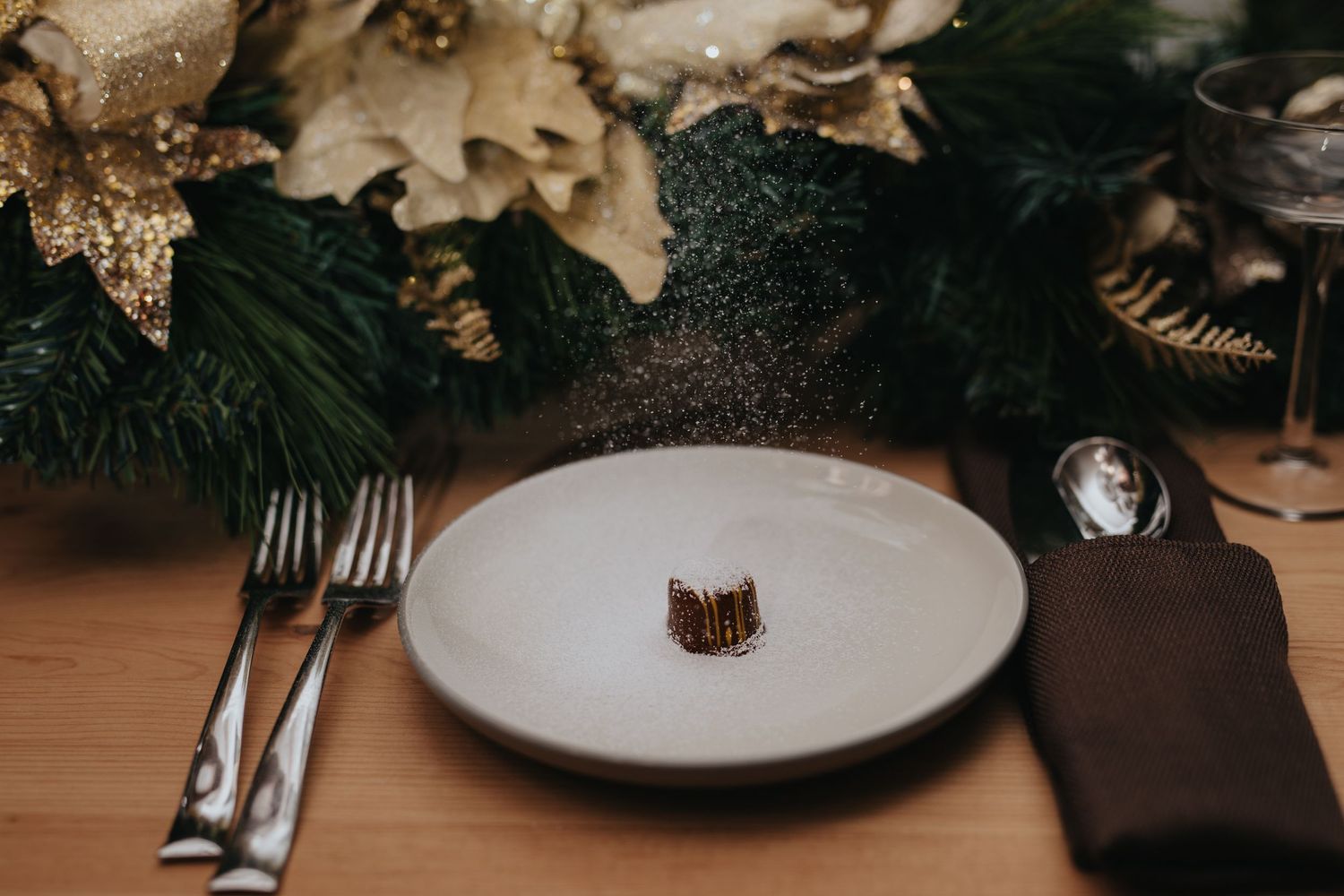 Elegant place setting with gold accents and decorative elements on dark background.