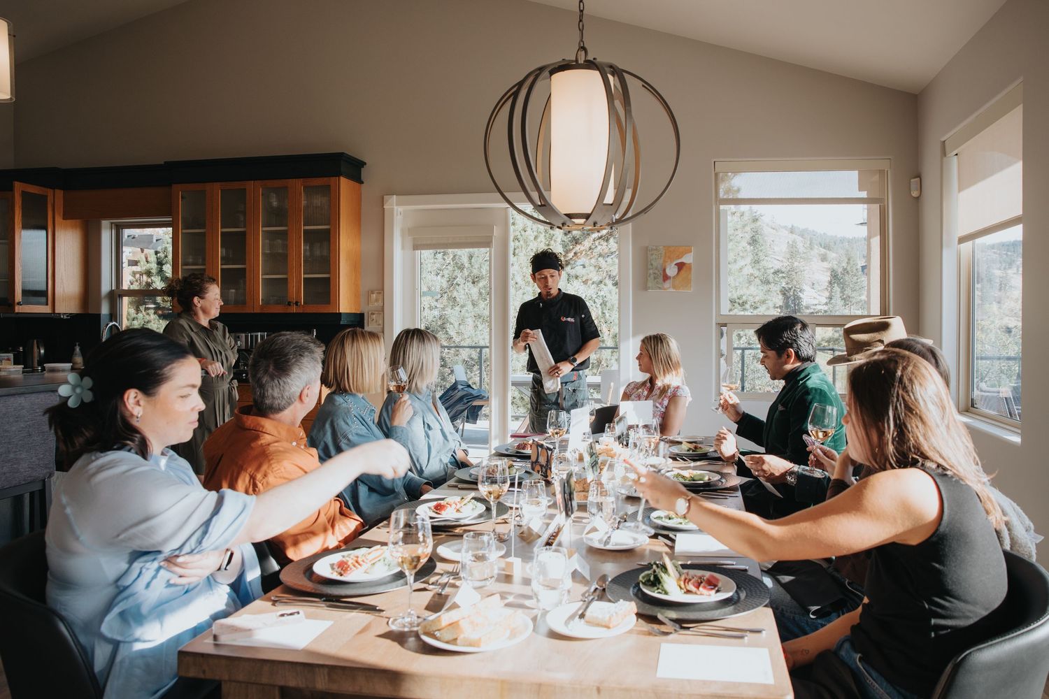 Casual dining scene with people sharing a meal in a modern home setting.