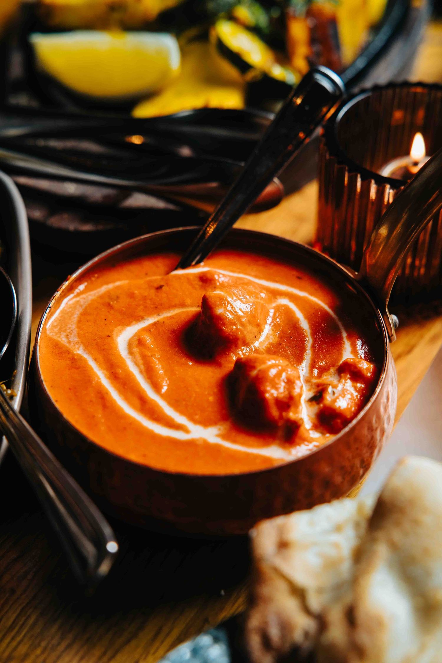 Close-up of creamy tomato soup being poured into a bowl with decorative swirl.