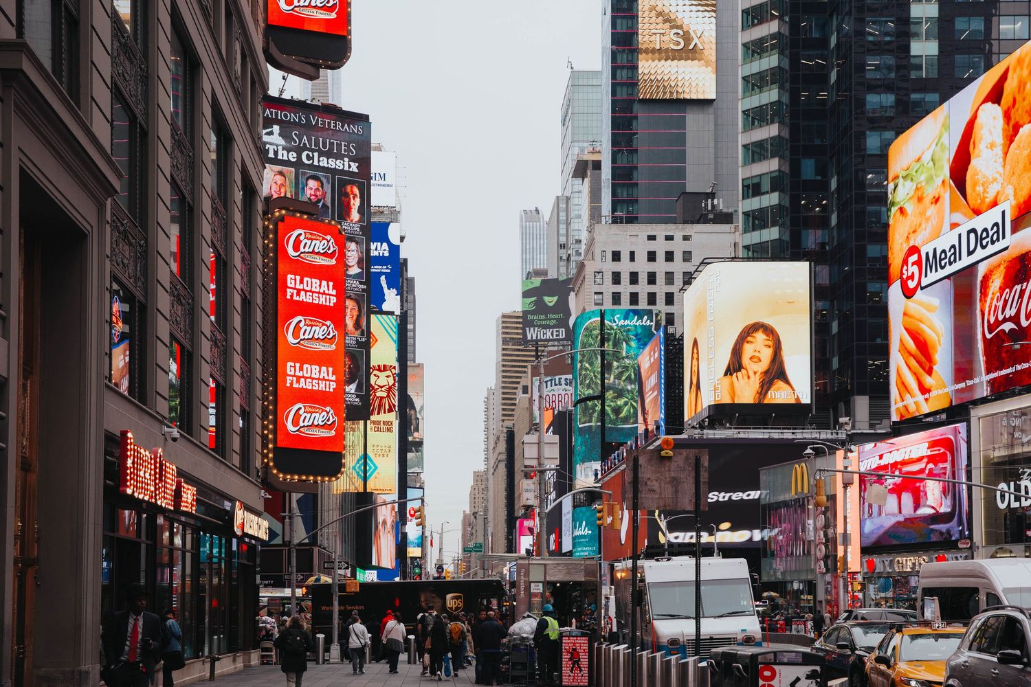 Busy Times Square street scene with colorful billboards and advertisements.