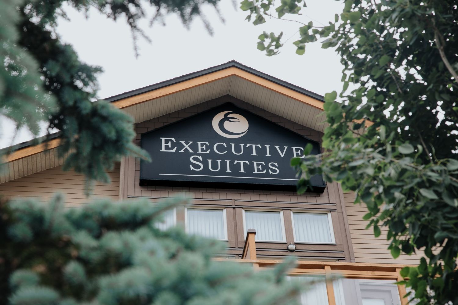 Executive Suites signage on upscale mountain resort building with rustic architecture.