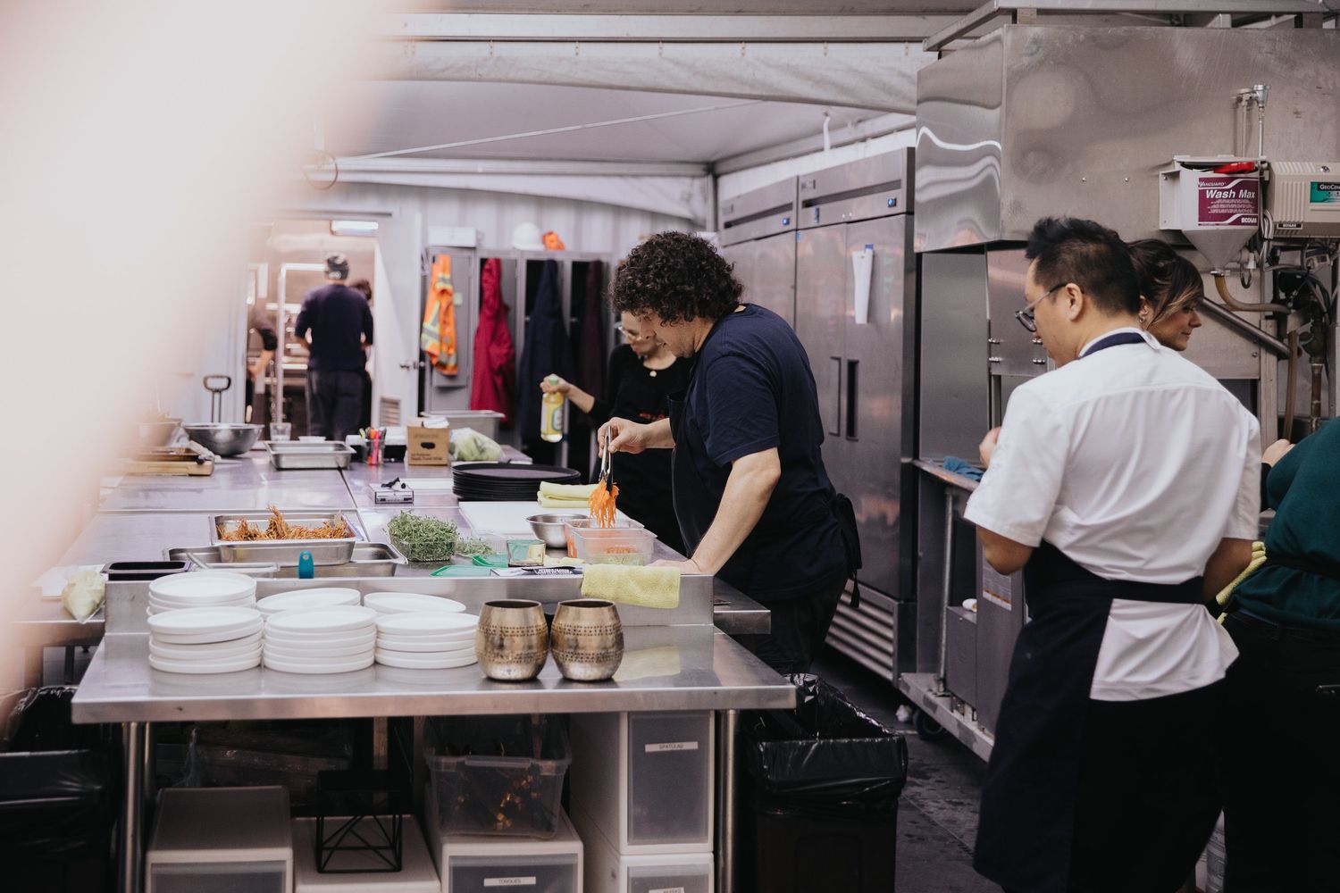 Commercial kitchen staff preparing meals in a professional restaurant setting.