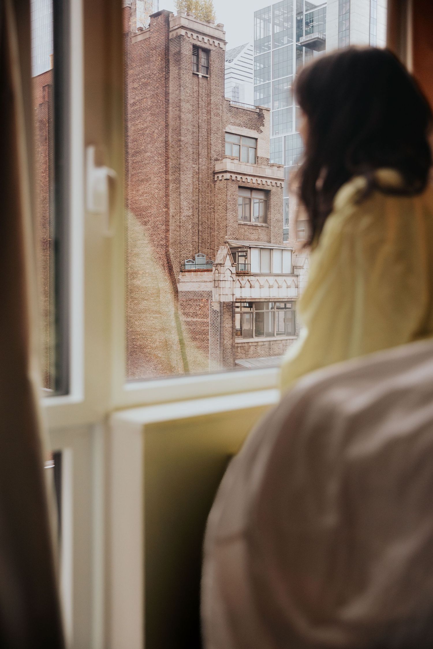 View of brick buildings and city skyline through a window.