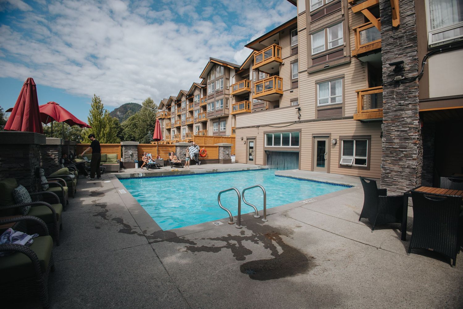 Outdoor swimming pool area of luxury apartment complex with mountain views.