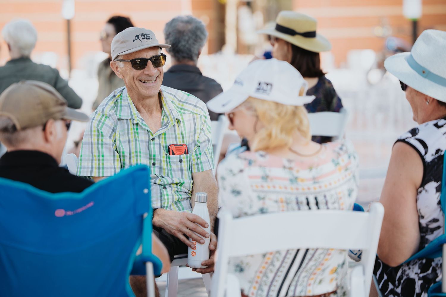 People enjoying refreshments at an outdoor cafe patio on a sunny day.
