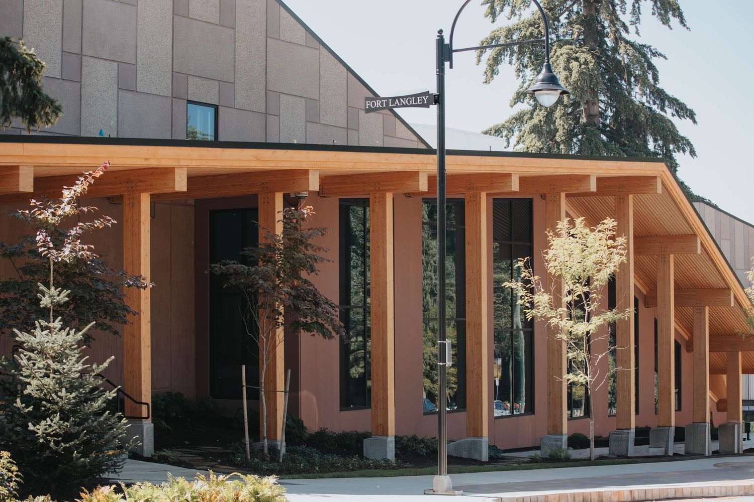Long view of a modern commercial building with covered walkway and columns.
