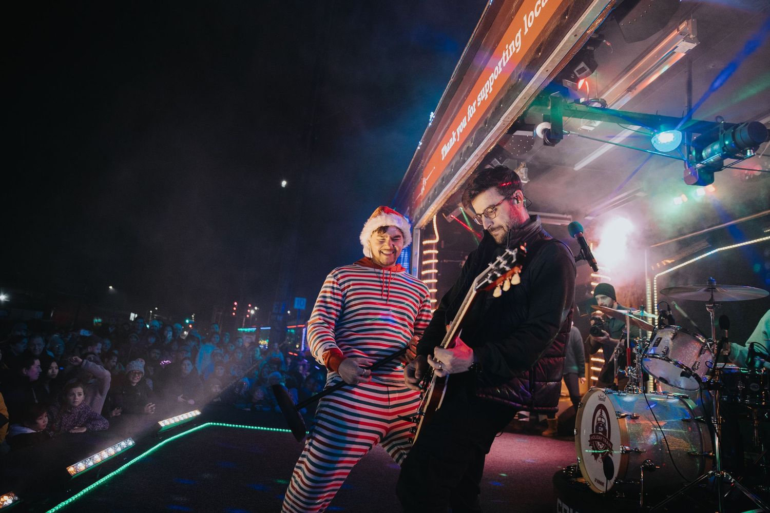 Musicians performing on stage with dramatic lighting and fog effects.