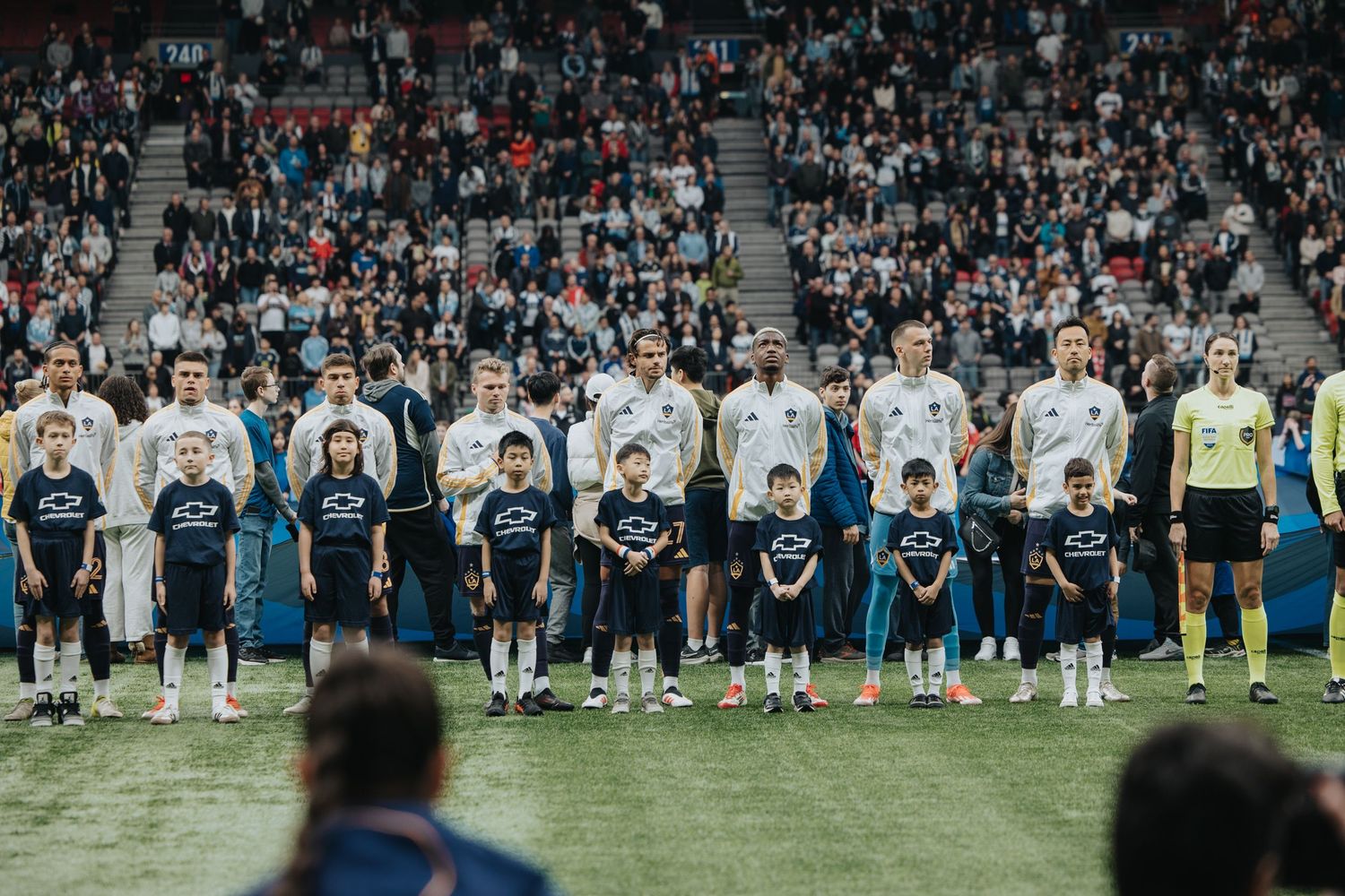 Team lineup on soccer field with players standing in formation before a match.