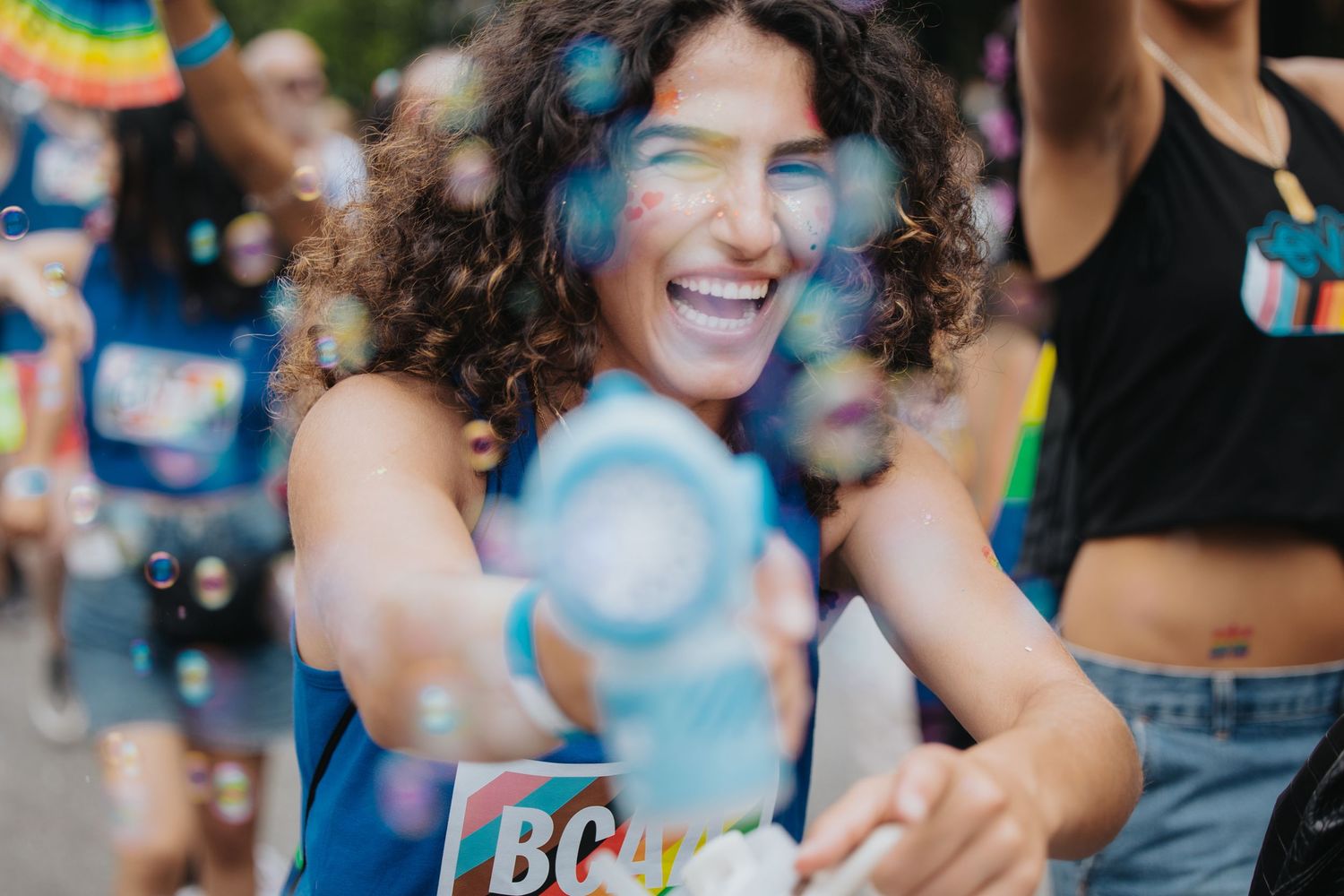 Diverse group enjoying an outdoor celebration with colorful decorations and smiles.