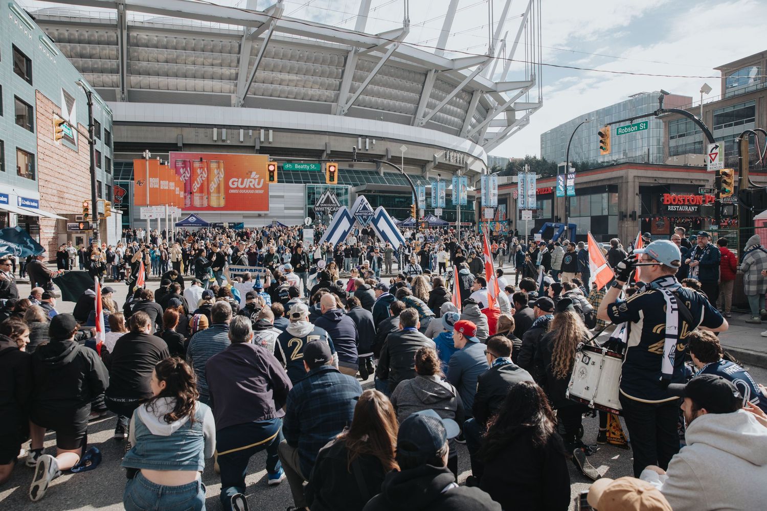 Dense crowd of sports fans assembled outside stadium entrance before a match.