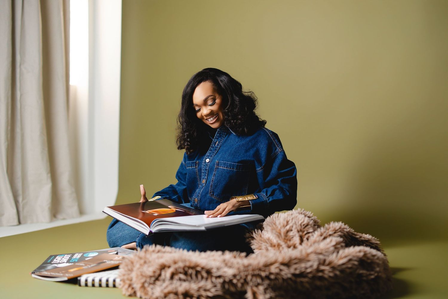 Person studying with notebook by window in cozy room setting.
