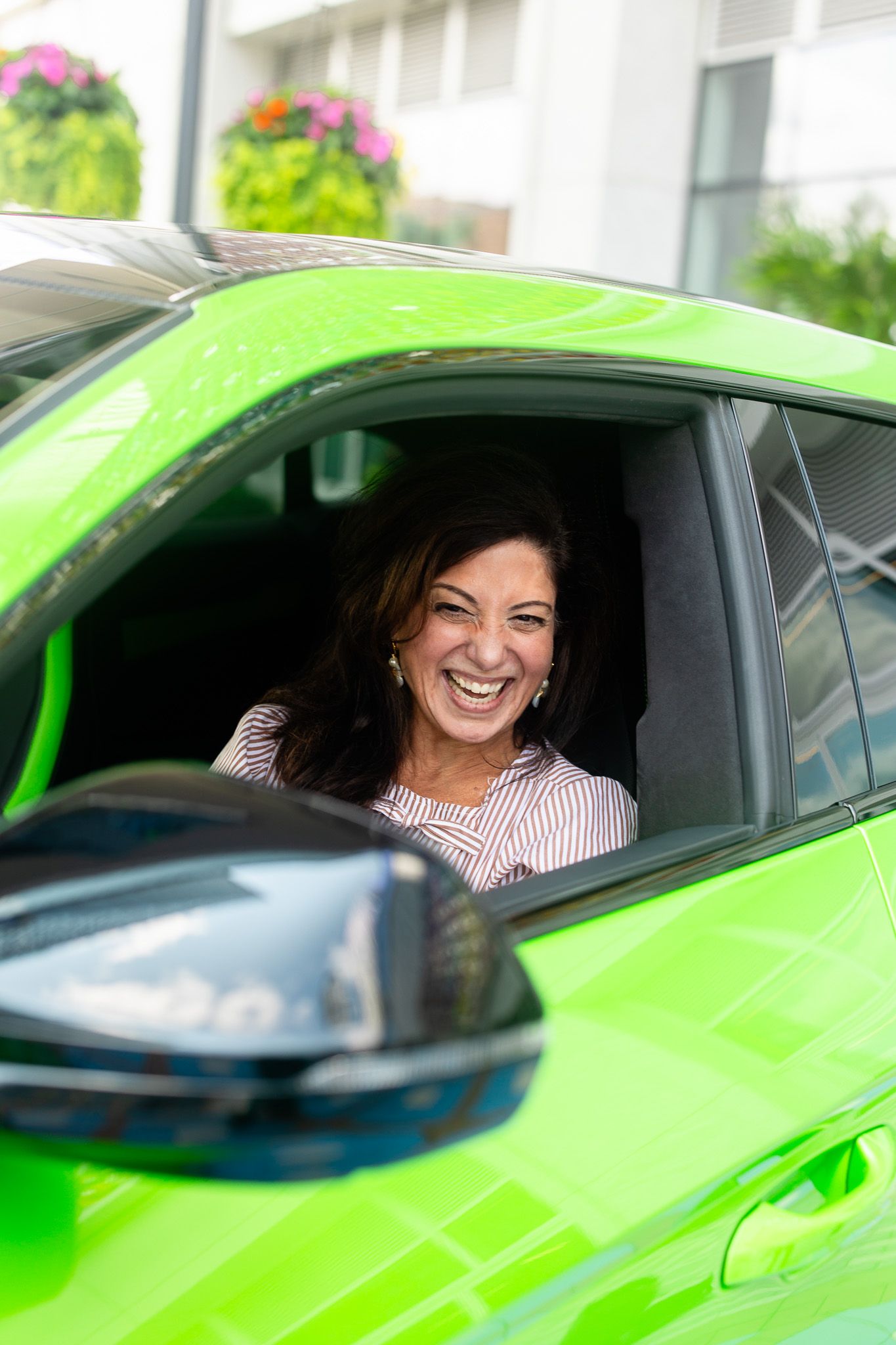 Person driving bright lime green sports car with excited expression.