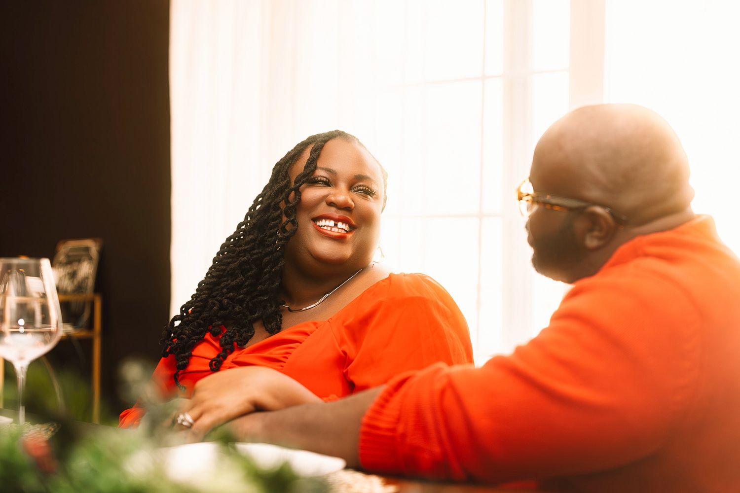 Two people in bright orange clothing having an animated conversation.