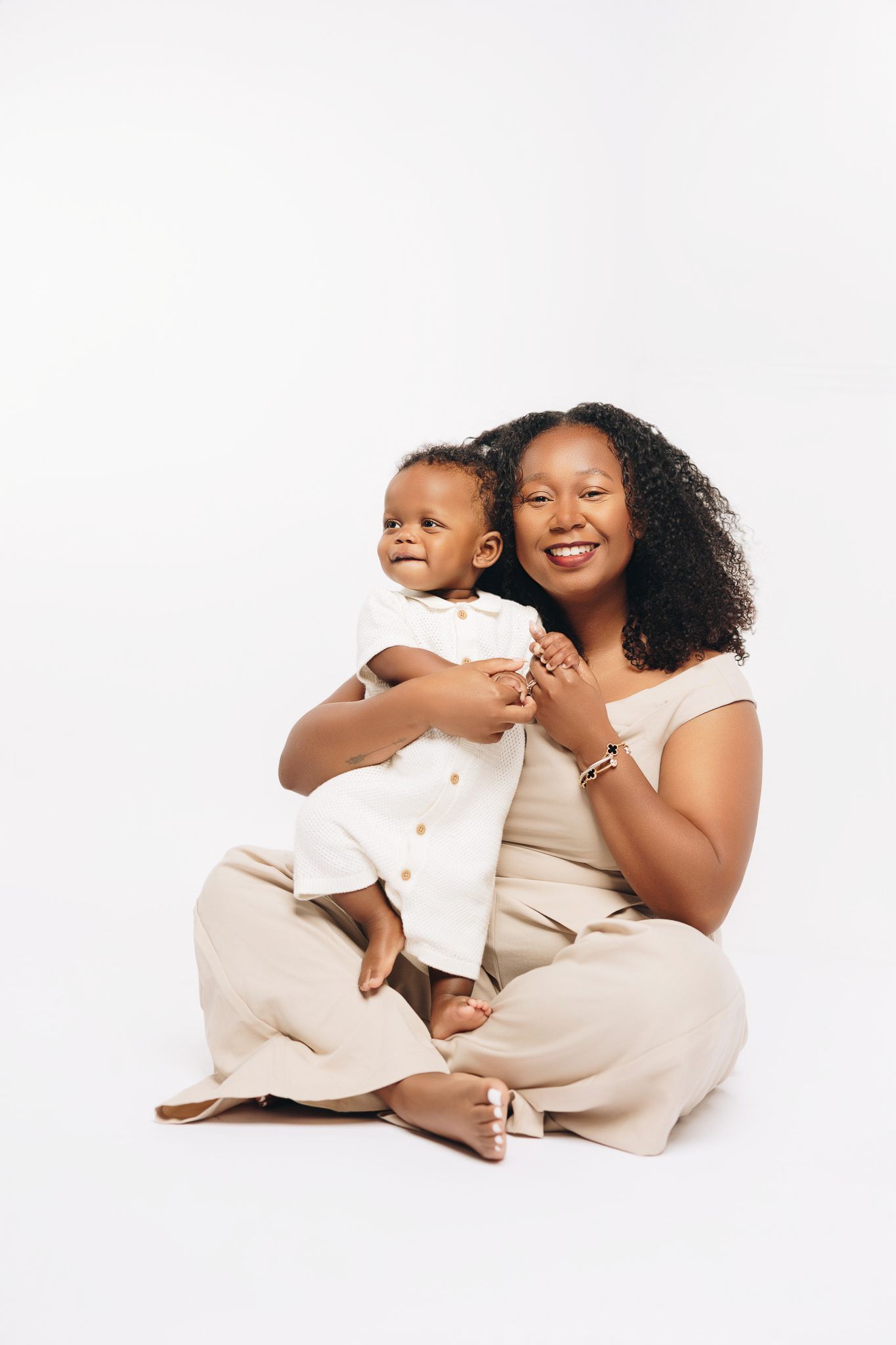 Heartwarming family portrait series in white outfits against clean white background.