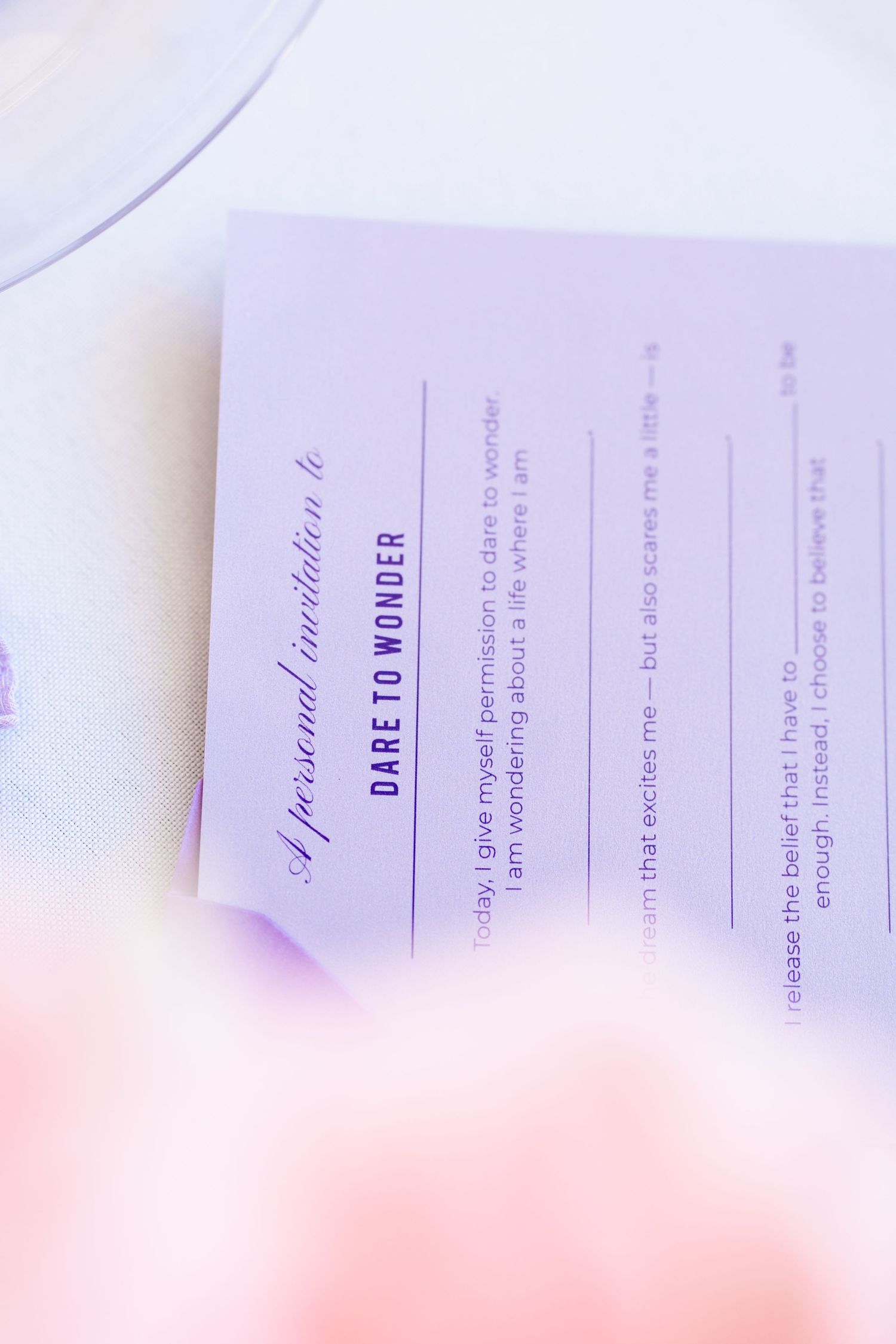 A personal invitation card titled Dare to Wonder with purple text on white paper, featuring inspirational prompts.