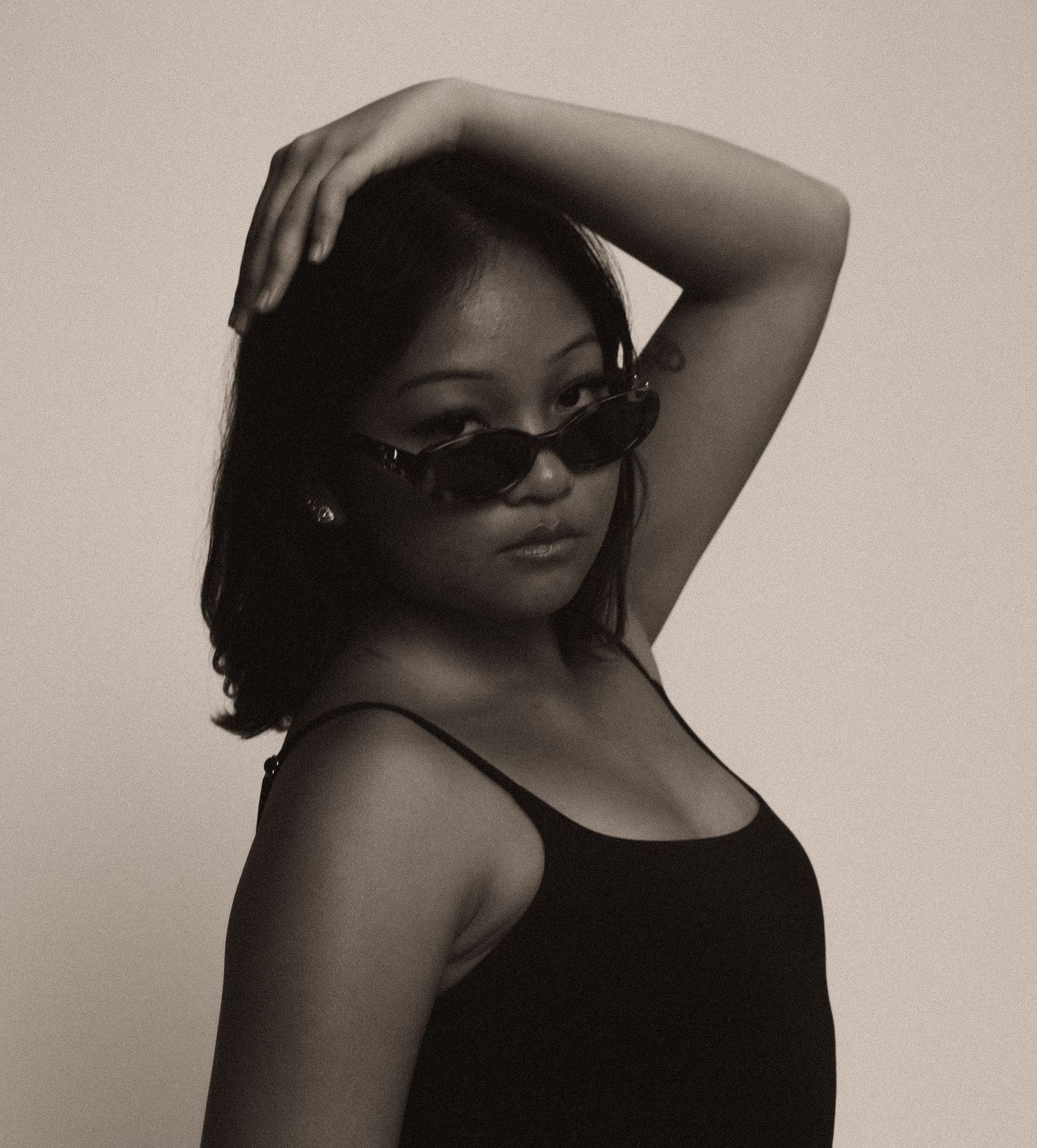 Artistic black and white photo series showing a person in sunglasses striking different dramatic poses against neutral backdrop.