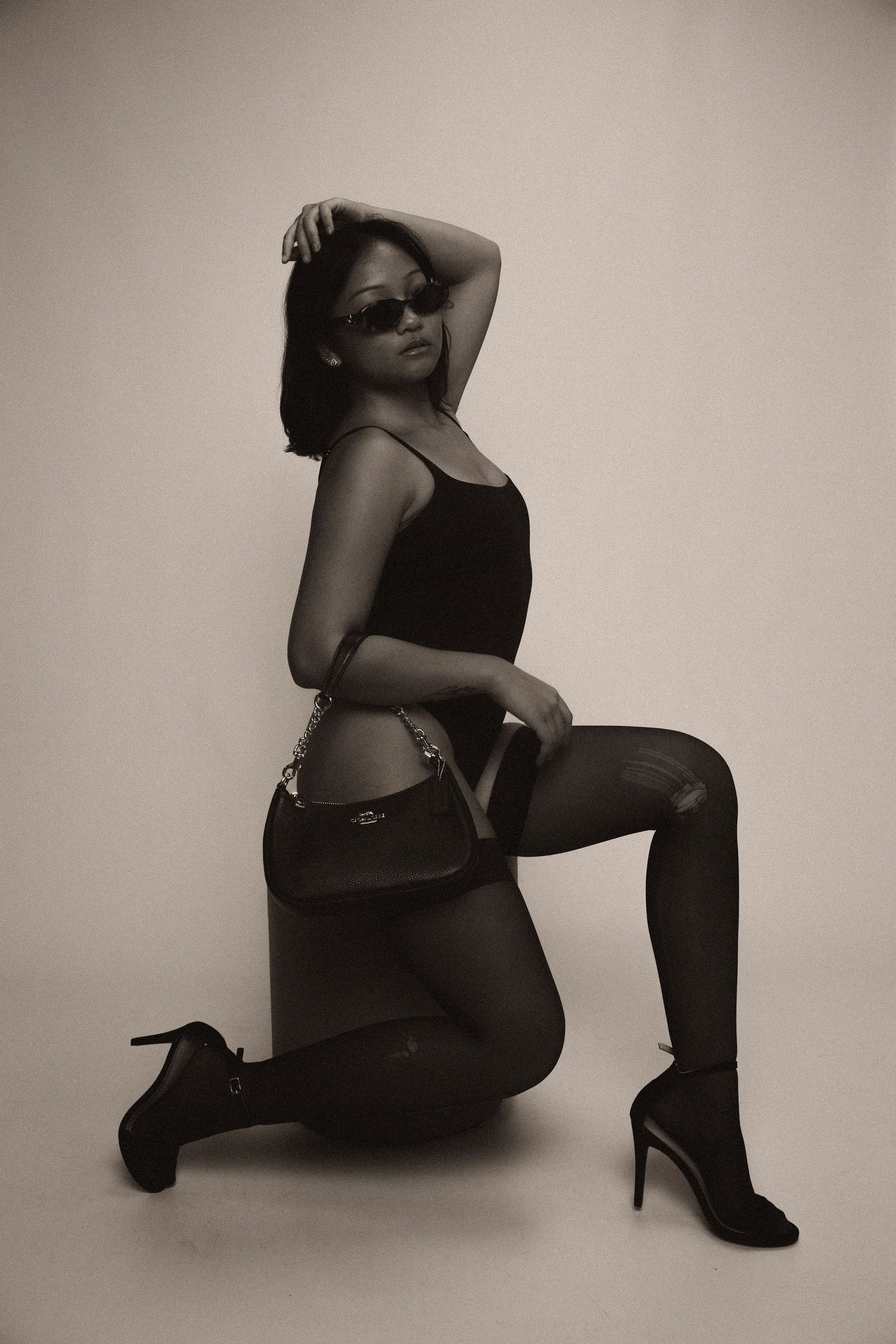 A series of artistic black and white fashion photographs showing poses in high heels against a neutral background.