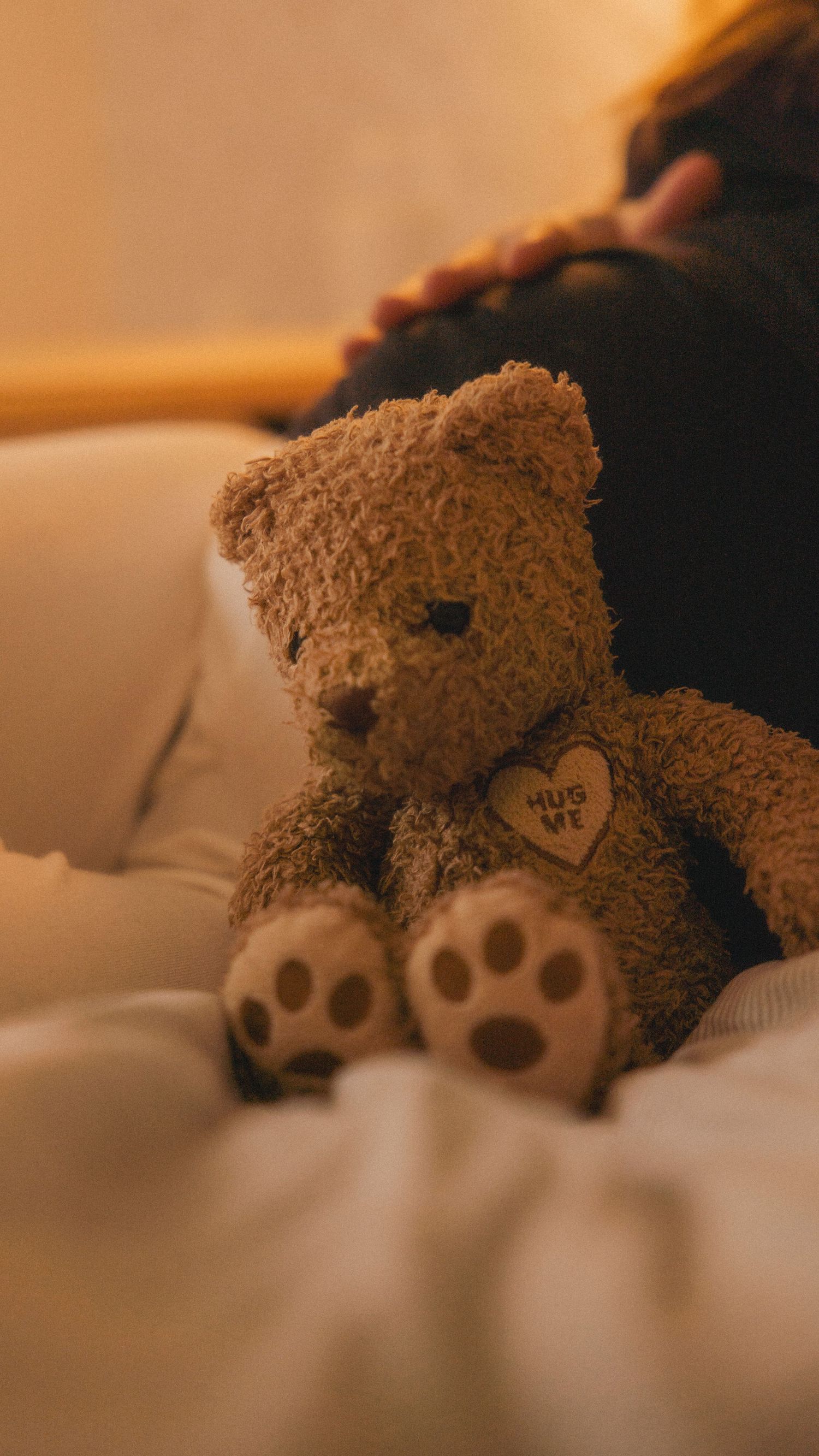 Mjuk nallebjörn i varmt morgonljus under en mysig och dokumentär gravidfotografering hemma