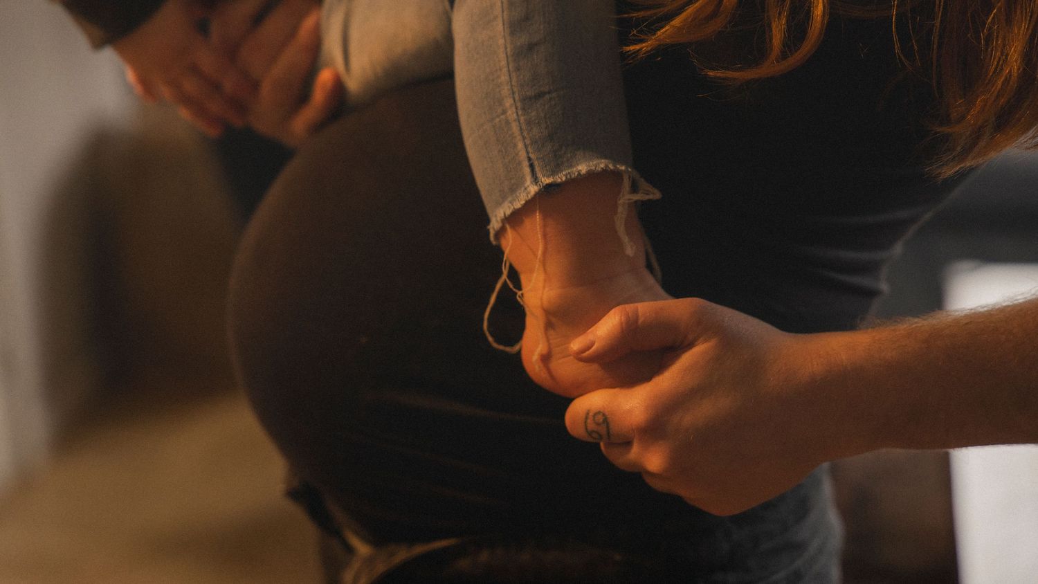 Närbild på barn och gravid mage som väntar på ett nytt familjemedlem.