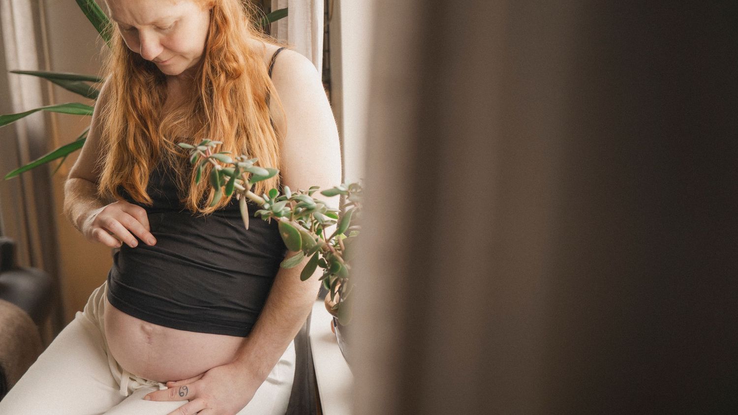 Blivande mamma som landar i stunden under en lugn och dokumentär gravidfotografering hemma