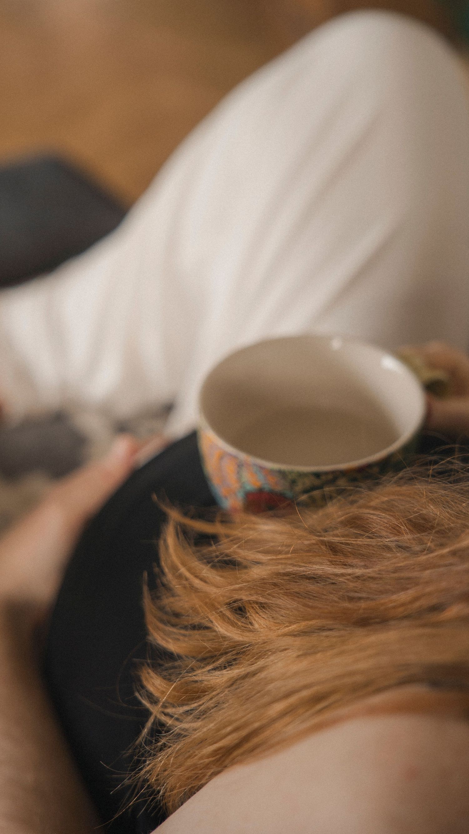 Varm kopp i morgonljus under en lugn och dokumentär gravidfotografering hemma