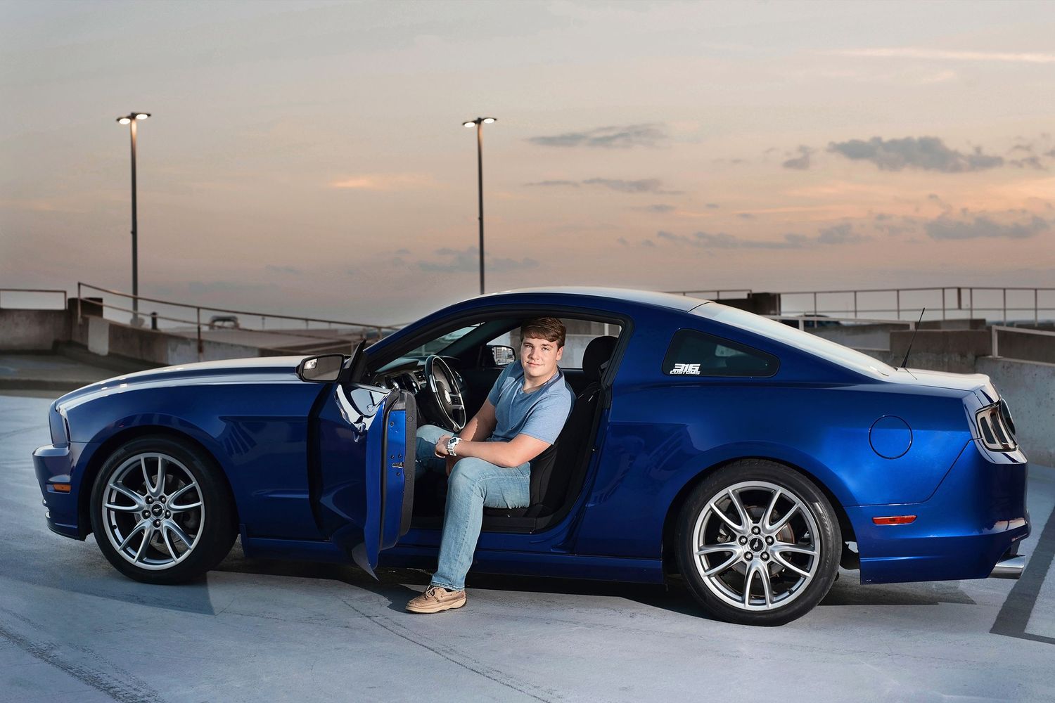 Senior boy at sunset with a car