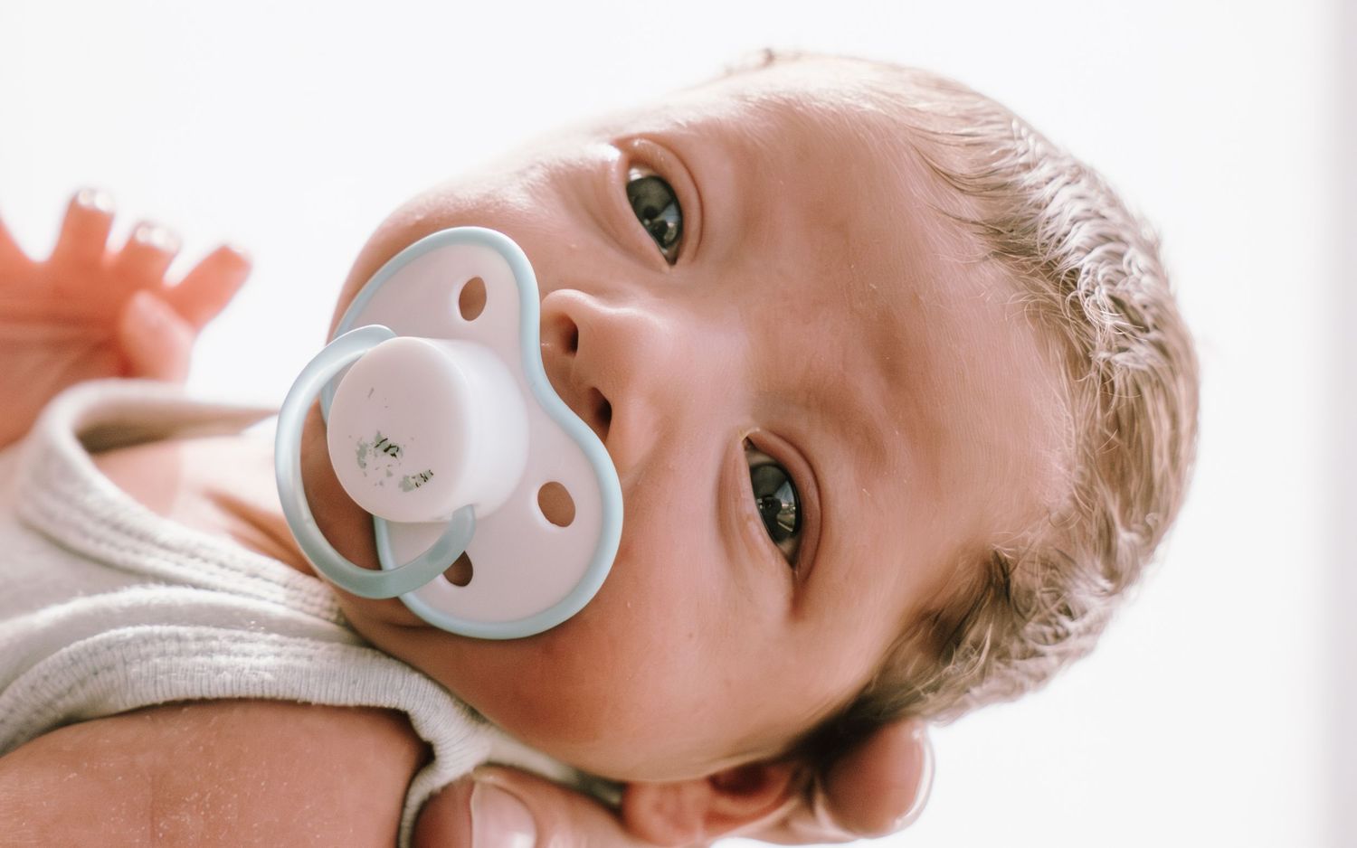 Close-up shots of a baby with a pacifier showing different expressions and angles.