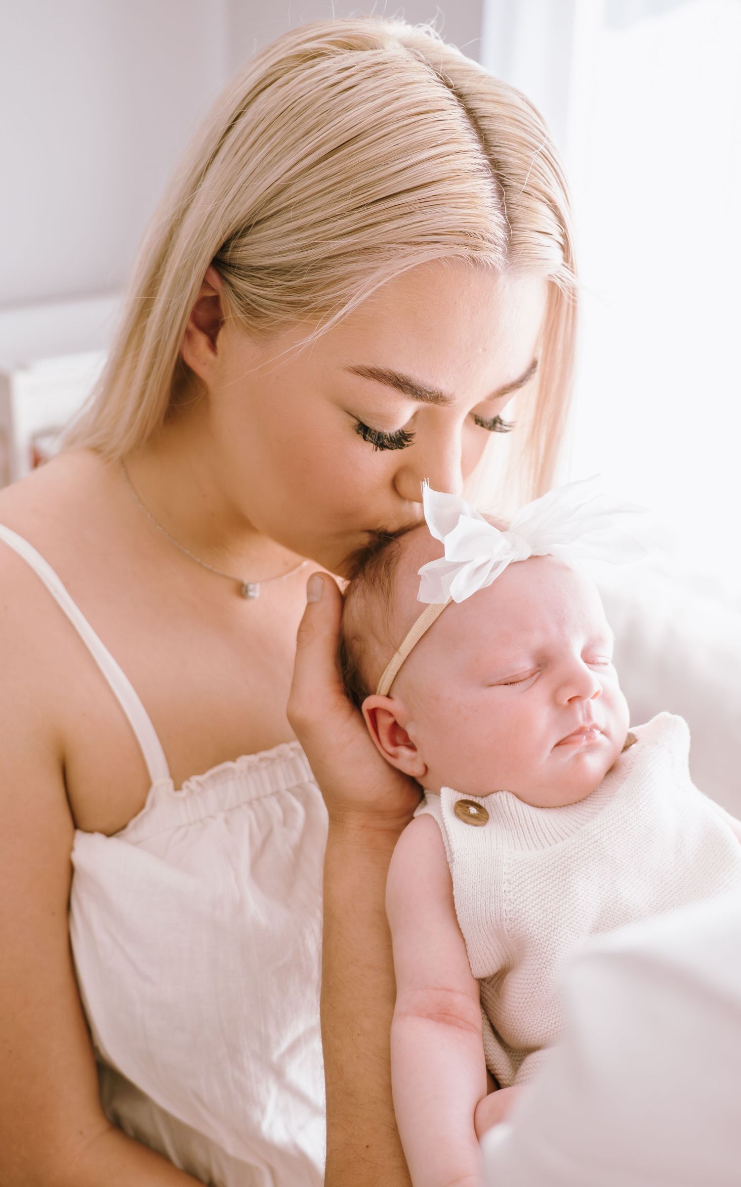 Gentle intimate portraits showing nurturing moments between parent and infant in natural light setting.
