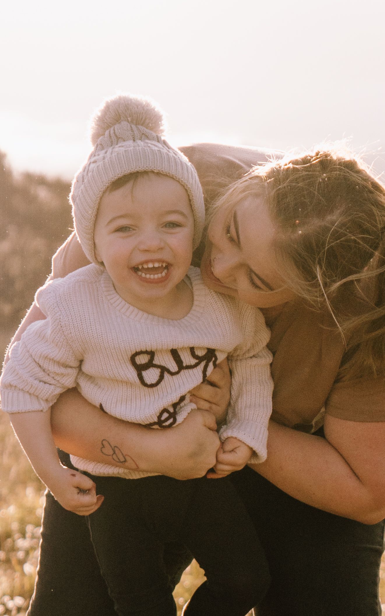 A heartwarming series of candid outdoor moments between parent and child in warm sunlight wearing matching winter attire.