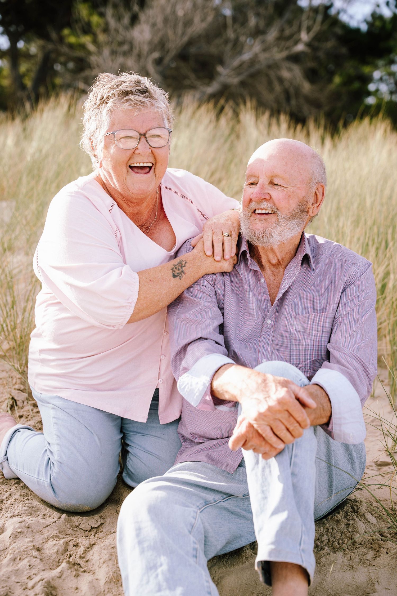 Candid series of joyful moments between a couple sitting together on a sandy beach.