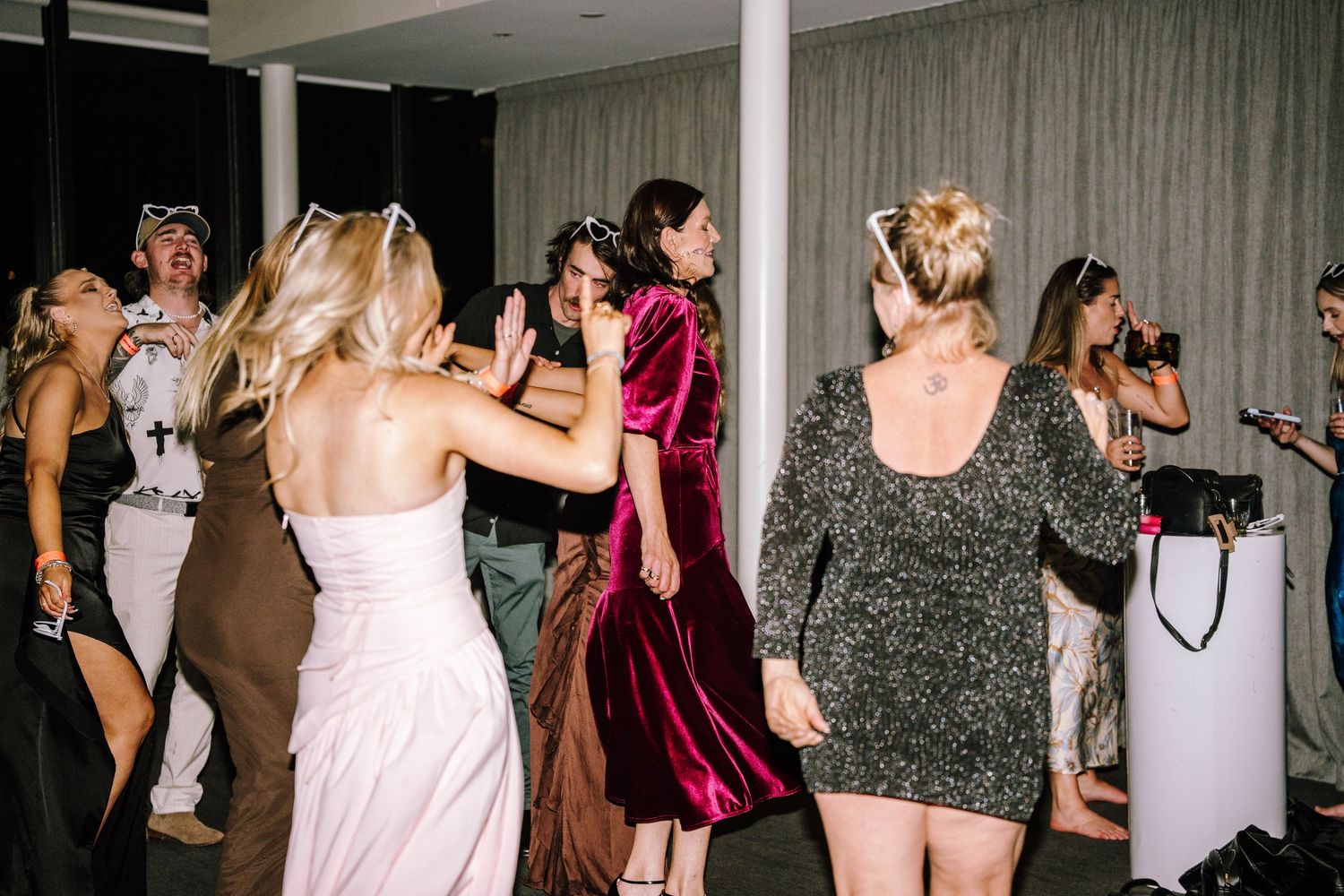 Guests dancing and celebrating at a wedding reception party in elegant formal attire.