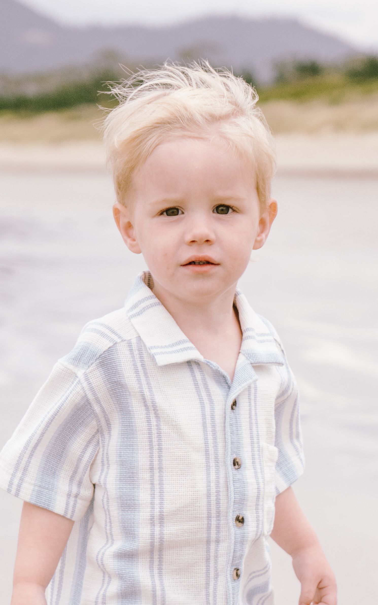 A series of four similar photos showing a small child in a white striped shirt against a light background.