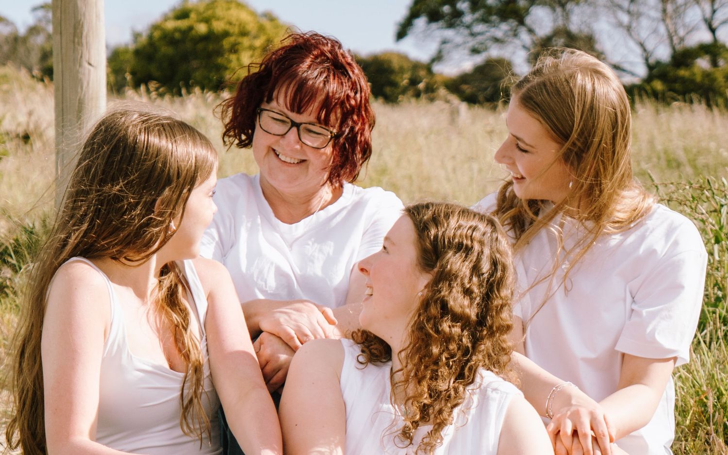 A series of candid outdoor photos showing tender moments between people in white shirts against a natural backdrop.