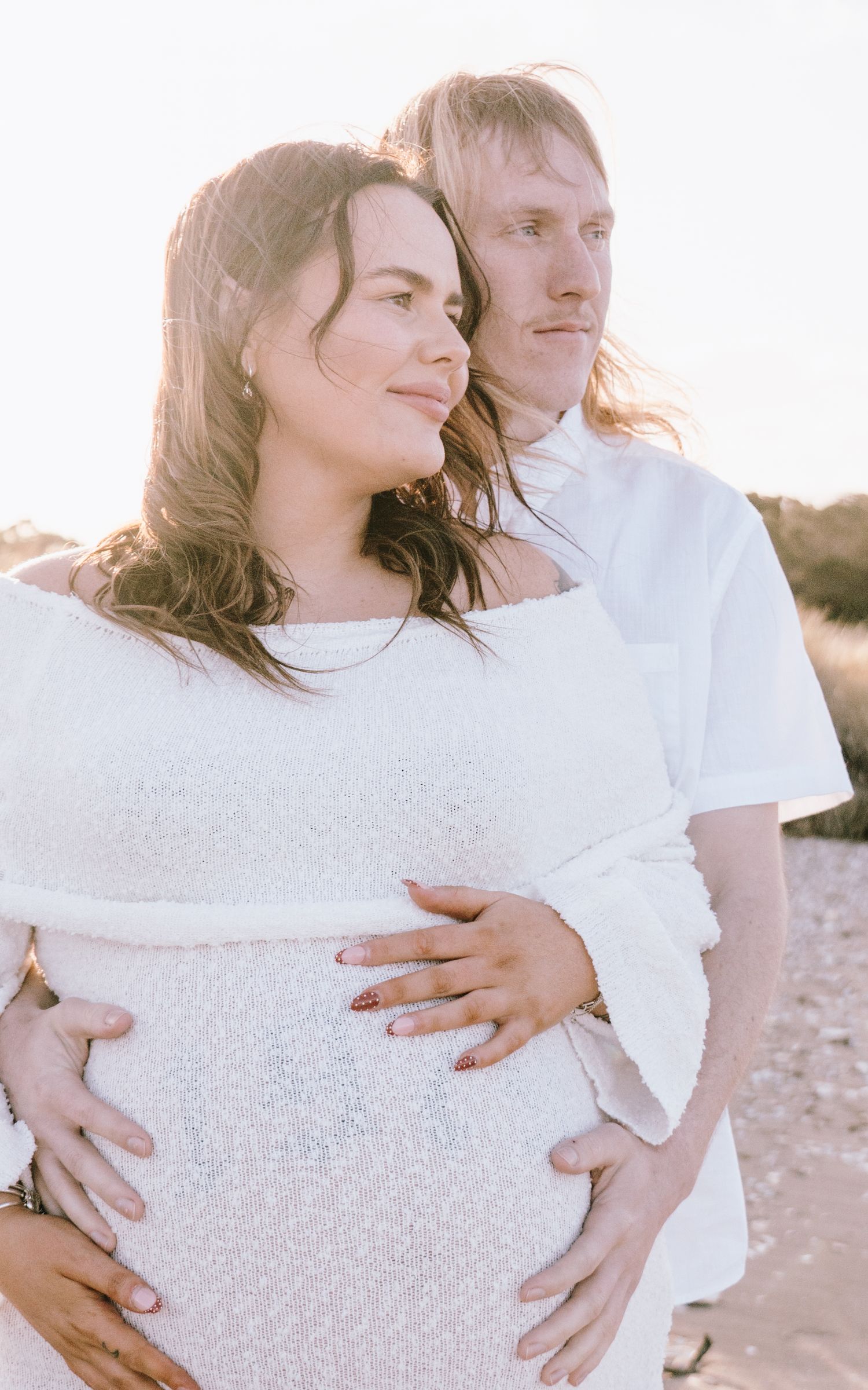 Romantic couple in white outfits embracing on beach during golden hour sunset in three sequential photos.