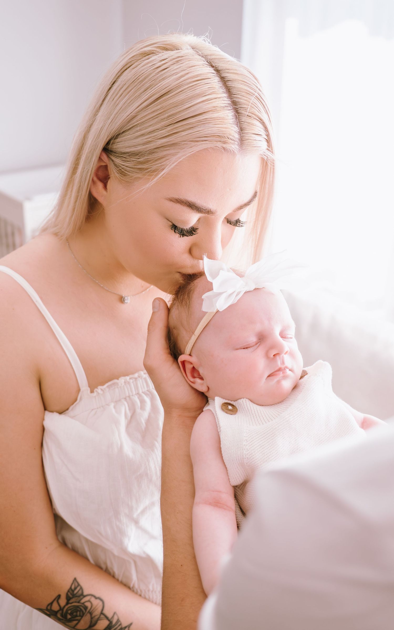 A tender moment between parent and baby in soft natural light indoors.