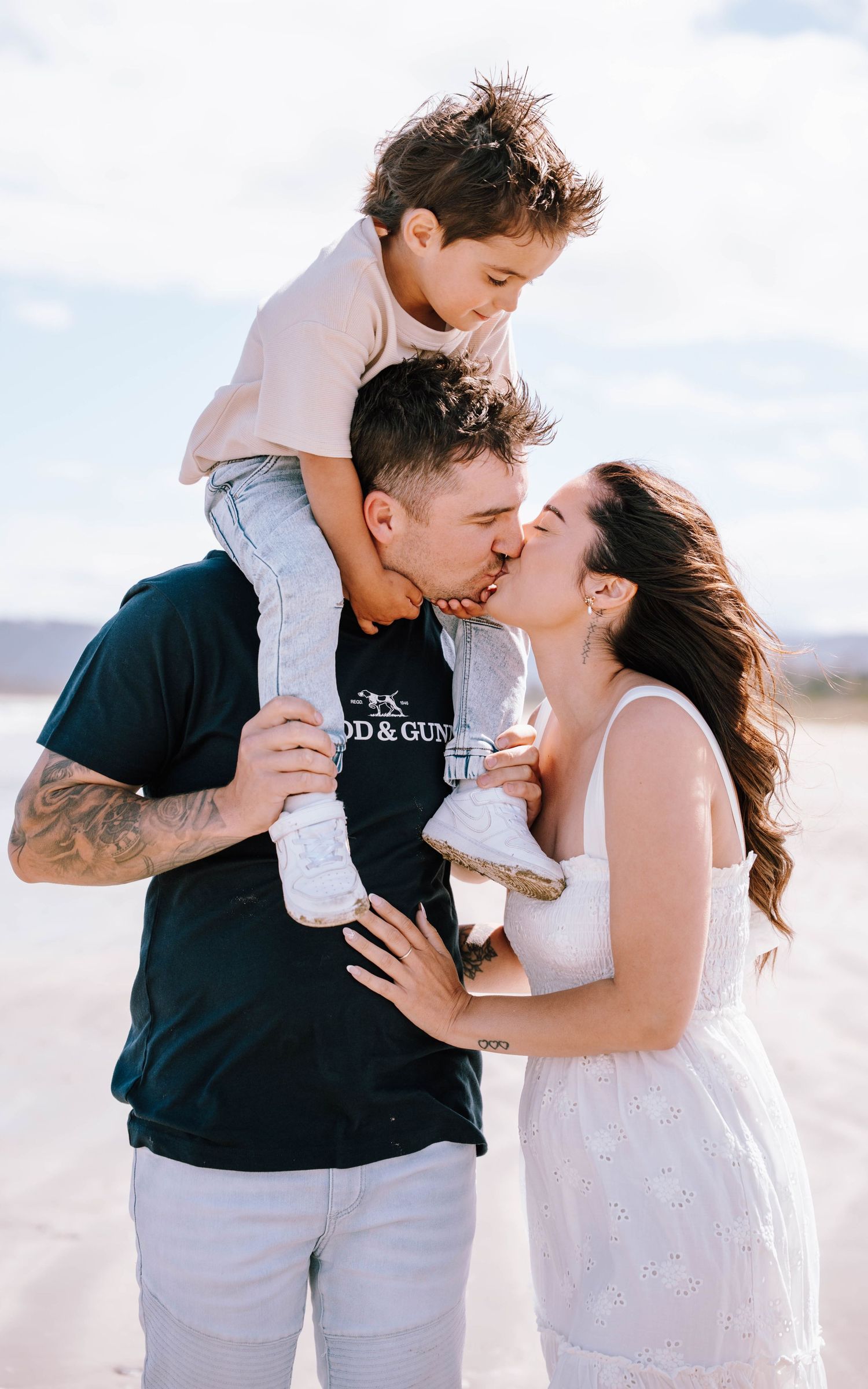 A loving family shares a tender moment together on a bright sunny day at the beach.