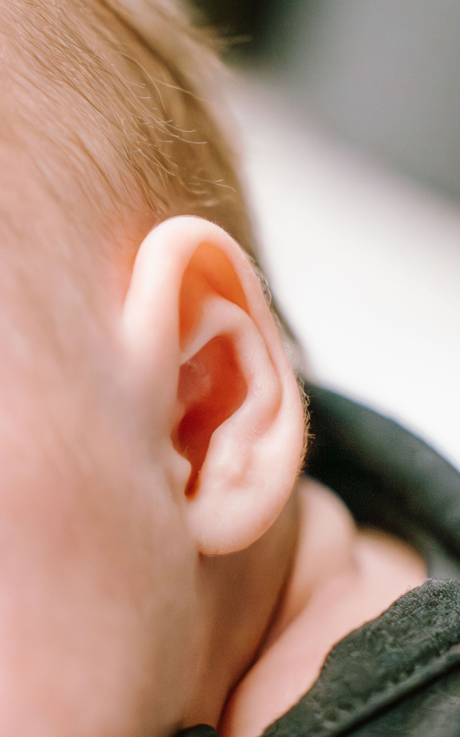 Close-up view of a human ear showing delicate anatomical details and skin texture in natural lighting.